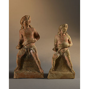 Two statuettes depicting two young satyrs holding a wineskin